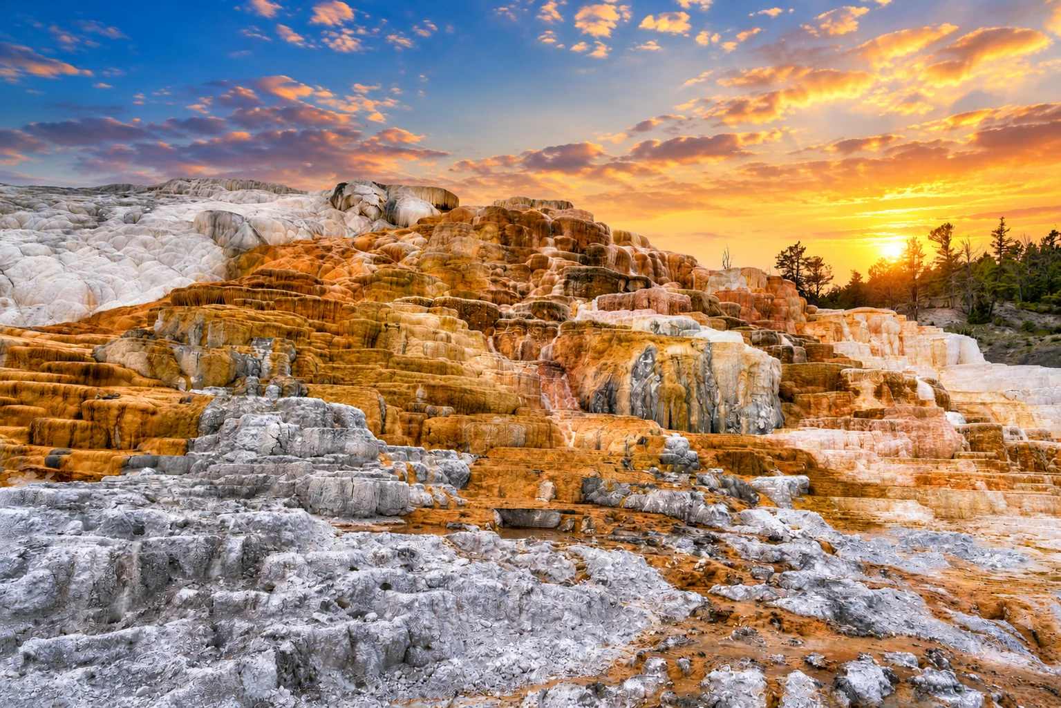 A glowing sunset over textured mineral terraces.